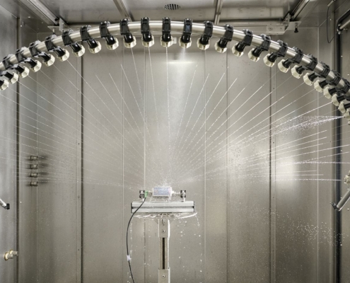 Spritzwasserprüfung in einer iTS-Spritzwasserkammer SPK R800: Das Schwenkrohr besprüht den Prüfling auf dem Drehteller