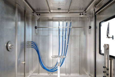 Vier feste IPX9K-Lanzen am Rahmen unter der Decke im Prüfraum einer Spritzwasserkammer SPK, davor der Drehteller
