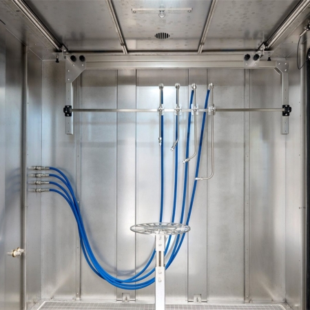 Vier feste IPX9K-Lanzen am Rahmen unter der Decke im Prüfraum einer Spritzwasserkammer SPK, davor der Drehteller