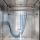 Vier feste IPX9K-Lanzen am Rahmen unter der Decke im Prüfraum einer Spritzwasserkammer SPK, davor der Drehteller